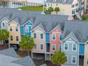 Exterior view of colorful townhomes, with covered parking and palm tree landscaping at 81 Sandbar Ln # 23, Folly Beach, SC 29439