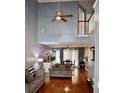 Spacious living room boasts soaring ceilings, hardwood floors, a ceiling fan and a view into the dining and kitchen area at 9122 Maple Grove Dr, Summerville, SC 29485