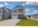 Charming two-story home with gray siding, a balcony, a well-manicured lawn, and a two car driveway at 101 Patterson Ave, Goose Creek, SC 29445