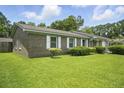 Charming brick home featuring a well-kept lawn, mature landscaping, and a welcoming curb appeal at 102 Berkshire Ct, Goose Creek, SC 29445