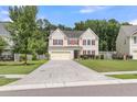 A lovely two-story home with a spacious driveway and lush green lawn, perfect for families at 127 Rawlins Dr, Summerville, SC 29485