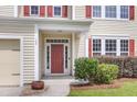 Inviting front entrance with a red door, manicured bushes, and classic architectural details at 127 Rawlins Dr, Summerville, SC 29485
