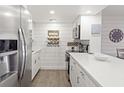 Modern kitchen featuring stainless steel appliances, white cabinets, quartz countertops, and hardwood floors at 1326 Sea Elder Dr, Kiawah Island, SC 29455