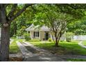 Charming home with a well-manicured lawn, mature trees, and a welcoming front porch at 1431 Whispering Oak Trl, Mount Pleasant, SC 29466