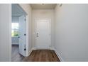 Inviting entryway featuring wood flooring, neutral walls, and a white front door with traditional design at 153 Royal Cainhoy Way, Huger, SC 29450