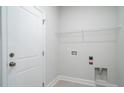 Functional laundry room features a white door, wire shelf, and utility connections for appliances at 153 Royal Cainhoy Way, Huger, SC 29450