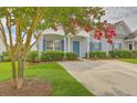 Charming gray home with blue shutters and a well-manicured front yard creates a welcoming curb appeal at 159 Townsend Way, Summerville, SC 29483
