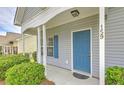Close up of charming gray home with blue door and well-manicured landscaping at 159 Townsend Way, Summerville, SC 29483
