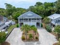 An elevated exterior shot of a beach house showcasing lush landscaping and ample parking at 1604 Jungle Rd, Edisto Island, SC 29438