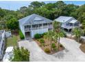 An elevated view of a beach home surrounded by lush trees and well-manicured landscaping at 1604 Jungle Rd, Edisto Island, SC 29438