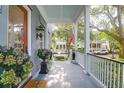 Inviting porch with classic columns, beautiful flowers and view of the neighborhood at 183 Ionsborough St, Mount Pleasant, SC 29464