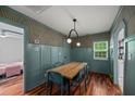 Dining room with a large wooden table, blue chairs, eye-catching wallpaper, and wainscoting at 1940 Orangeburg St, North Charleston, SC 29405
