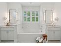 Elegant bathroom featuring a soaking tub, double sinks, and white marble tiling at 2828 Wagner Way, Mount Pleasant, SC 29466