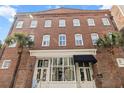 Charming brick building exterior with palm trees, street-level entrance, and windows at 4 Beaufain St # 207, Charleston, SC 29401
