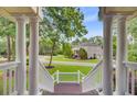 Inviting front porch featuring classic columns and views of the landscaped front yard and surrounding neighborhood at 4272 Persimmon Woods Dr, Charleston, SC 29420