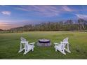 Relaxing backyard featuring an inviting fire pit and Adirondack chairs at 4808 Wilson Rd, Meggett, SC 29449