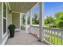 Inviting front porch with white columns, and outdoor lighting offering a cozy space at 5242 E Dolphin St, North Charleston, SC 29405