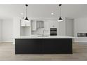 Modern kitchen with black island, stainless appliances, and white cabinetry at 564 Scholar Way, Summerville, SC 29486