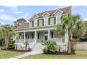 Inviting two-story home featuring a lovely porch, white railings, black shutters, and a well-kept lawn at 591 Two Mile Run, Johns Island, SC 29455
