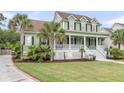 Beautiful home with a lush green lawn, a spacious porch, and elegant landscaping with various plants at 591 Two Mile Run, Johns Island, SC 29455