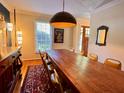Dining room featuring a long wooden table with seating for eight, a light fixture, and hardwood floors at 8 Brisbane Dr, Charleston, SC 29407