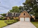 Two-story brick home with an attached two-car garage, driveway, and mature landscaping at 8 Brisbane Dr, Charleston, SC 29407