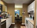 The cozy kitchen with white cabinets opens up to the dining area at 806 Greenmeadow Dr, Goose Creek, SC 29445