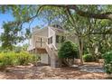 Inviting raised beach house with a charming staircase, set amidst mature trees and lush landscaping at 811 Treeloft Trce, Seabrook Island, SC 29455