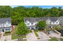 Aerial view of a residential area showcasing well-maintained homes surrounded by lush greenery and mature trees at 9049 Parlor Dr, Ladson, SC 29456