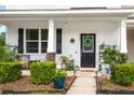 Cozy front porch adorned with plants and stylish decor, creating a charming and inviting outdoor space at 9049 Parlor Dr, Ladson, SC 29456