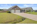 Attractive home with two-car garage, long driveway, and a well-maintained lawn at 104 Wild Orchid Way, Huger, SC 29450