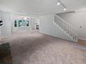 Open living space with carpet and staircase featuring seamless flow and neutral palette at 109 Evance Ct, Summerville, SC 29485