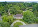 Picturesque aerial view of the home nestled among lush trees and overlooking a serene pond at 115 Old Postern Rd, Summerville, SC 29483