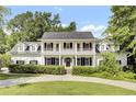 Stunning two-story home with a spacious porch, black shutters, and a lush green lawn at 115 Old Postern Rd, Summerville, SC 29483