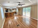 Open-concept living space with hardwood floors, bar seating, and sliding glass doors leading to an outdoor deck at 149 Old Red Hill Rd, Ridgeville, SC 29472