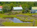 An aerial view of a home nestled among lush greenery near a scenic marsh at 1520 Regimental Ln, Johns Island, SC 29455