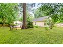 Expansive backyard with lush green grass and mature trees provides a private outdoor space at 202 Chandler Dr, Ladson, SC 29456