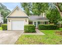 Quaint house with a one-car garage, lovely yellow siding, and greenery enhancing the curb appeal at 202 Chandler Dr, Ladson, SC 29456