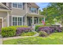 Charming two-story home featuring a cozy front porch, lush landscaping, and a welcoming American flag at 206 President Cir, Summerville, SC 29483