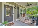 Inviting front porch featuring comfortable seating, decorative shutters, and stylish outdoor lighting at 206 President Cir, Summerville, SC 29483