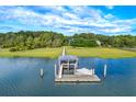 Waterfront home featuring a private dock with boat lift, providing direct access to tranquil blue waters at 2287 Shoreline Dr, Johns Island, SC 29455