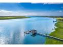 Scenic waterfront view featuring a private dock with boat lift extending into calm blue waters and green landscape at 2287 Shoreline Dr, Johns Island, SC 29455