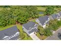 Beautiful two-story gray home, with a spacious driveway, and lush greenery near a pond and golf course at 5256 Mulholland Dr, Summerville, SC 29485