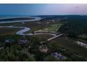 Scenic aerial view captures 79 Trailing Vine near winding rivers, golf course, and the ocean in the distance at 79 Trailing Vine Way, Kiawah Island, SC 29455