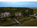 Aerial view of 79 Trailing Vine nestled amongst the trees, with a wooden walkway leading to the marshland at 79 Trailing Vine Way, Kiawah Island, SC 29455