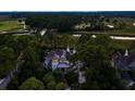 An aerial view shows the home's unique architecture and landscaping, with a patterned roof and multiple chimneys at 79 Trailing Vine Way, Kiawah Island, SC 29455