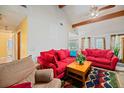 Bright living room featuring a vaulted ceiling, wooden beams, and comfortable red couches at 8204 Pleasant Ridge Dr, Charleston, SC 29420