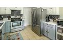Well-lit kitchen with stainless steel refrigerator and appliances and ample countertop space at 104 Queens Ct, Summerville, SC 29485