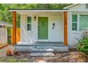 Inviting front porch featuring an eye-catching green door, rustic wood posts, and fresh landscaping at 1188 Camden St, North Charleston, SC 29405