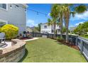Landscaped backyard with artificial grass, string lights, and a charming seating area, perfect for entertaining at 1530 Willtown St, Daniel Island, SC 29492